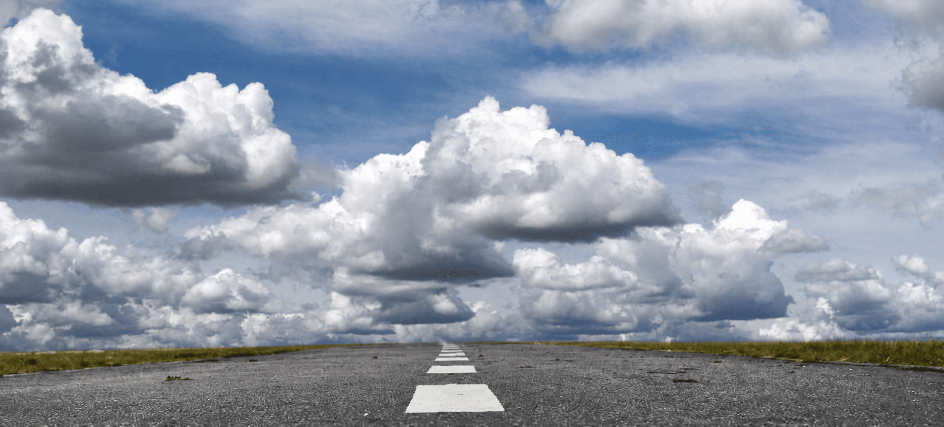 Ruta recta que se pierde en el horizonte bajo un cielo con nubes
